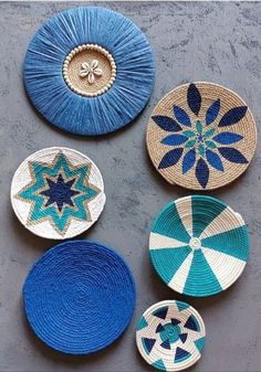 four woven baskets with blue and white designs on the bottom one has a star in the middle