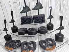 an assortment of different types of doughnuts on a glass plate with black icing