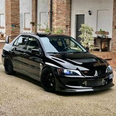 a black car parked in front of a brick building