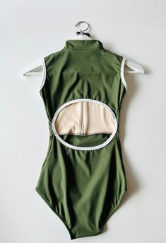 the back of a green bodysuit with white trim