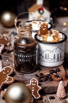 a table topped with cookies, hot chocolate and an ice cream container filled with marshmallows