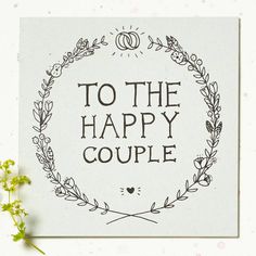 a card with the words to the happy couple written in black on it next to some flowers