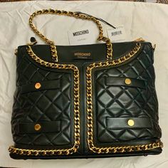 Moschino Couture Milano - Leather Quilted Black Jacket Very Good Condition. Used Outside Once, Then Stored. Please Review The Pictures Carefully For Signs Of Usage. There Are Light Scratches At The Upper Portion Of The Bag, Near The "Collar" Chain. Chain Is Still In Gold Hardware, But There May Be Some Slight Fading In Some Chain. Black Leather With Nylon Lining And Gold-Tone Hardware Approximately 15in Long X 6in Wide X 12in High. With Attached Chain-Leather Straps, And A Detachable 36in Black Leather Strap Comes With Dust Bag. Reasonable Offer Will Be Considered. Thank You. Luxury Shoulder Bag Tote With Pockets, Luxury Tote Shoulder Bag With Pockets, Luxury Shoulder Bag With Pockets For Business, Luxury Work Bags With Pockets, Luxury Workwear Bags With Pockets, Luxury Quilted Bags For Work, Moschino Bags, Moschino Couture, Collar Chain