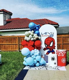 a bunch of balloons that are on the ground in front of a sign and some grass