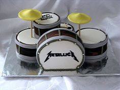 this is a cake with drums on it and the name metallic on top for someone's birthday