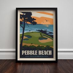 an image of a pebble beach california poster in black frame on wood flooring