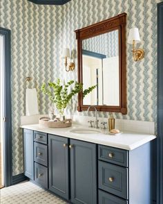 a bathroom with blue cabinets and white counter tops