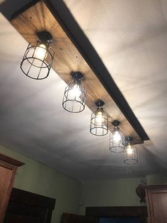 the light fixture is hanging from the ceiling with four lights on it, and there are three