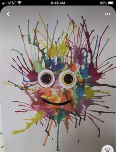 a child's art project with paint splattered on the face and eyes