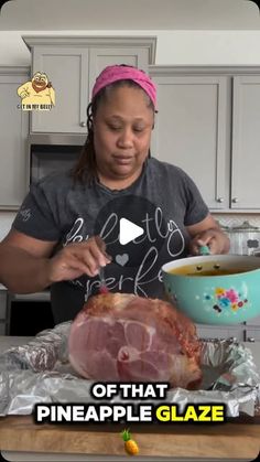 a woman is preparing a large piece of meat on tin foil with a bowl in front of her