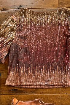 Half sleeve sequin top. From gold to copper red to rose gold. This fiery number will have you wanting to throw a party! Half puff sleeves with a hidden elastic cuff. Fully lined. Rounded neckline. 95% polyester/ 5% spandex; 100% polyester lining. Care instructions: hand wash cold with like colors, do not bleach, do not wring or twist, flat dry, cool iron if needed. Our standard young contemporary sizing. X-Small fits sizes 2-4, small fits sizes 5-7, medium fits sizes 8-10, large fits sizes 11-13 Metallic Embellished Tops For Party, Party Metallic Embellished Tops, Metallic Long Sleeve Top With Sequins, Fitted Sequined Tops For Holiday Party, Stretch Embellished Party Blouse, Embellished Stretch Blouse For Party, Party Tops With Sequins And Stretch, Festive Long Sleeve Top With Contrast Sequins, Gold Shimmer Stretch Tops