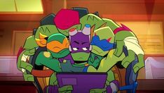 the teenage mutant ninjas are sitting in front of a laptop computer and looking at each other