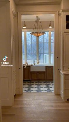 an open door leading to a kitchen with a sink and window