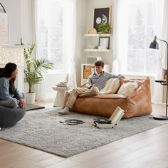 a man and woman sitting on a couch in a living room next to each other