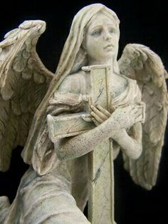 a statue of an angel holding a book