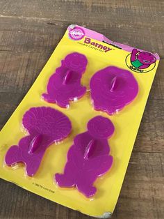 three purple cookie cutters sitting on top of a wooden table