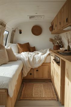 the inside of a camper with lots of furniture and pillows on it's bed