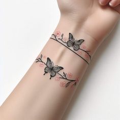 a woman's arm with two butterflies on it and pink flowers around the wrist