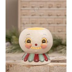 a small white and yellow lamp with a clown face on it