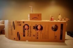 an open cardboard box sitting on top of a table with two pictures in the middle