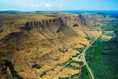 an aerial view of a valley with mountains in the background and roads winding through it