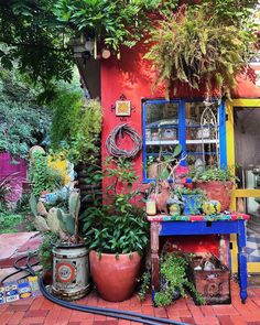 a colorful house with plants and other things in the front yard, including a potted plant