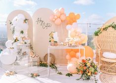 an outdoor party with balloons and flowers on the table, along with other decor items