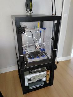 a large black and white machine sitting on top of a wooden floor