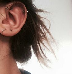 a close up of a person with ear piercings on their ears and behind the ear