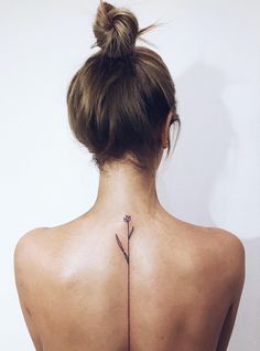 the back of a woman's neck is shown with an arrow tattoo on it