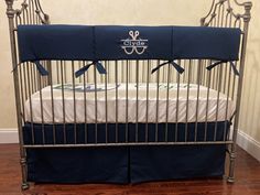 a metal crib with a blue and white blanket on it