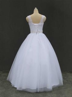 a white ball gown on a mannequin head stand in front of a black backdrop