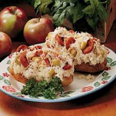 two pieces of bread with toppings on a plate next to apples and other vegetables