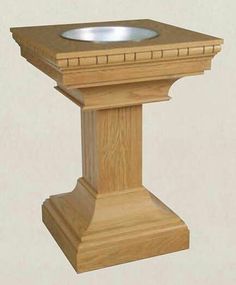 a wooden pedestal with a silver bowl on it's top and bottom part in the center