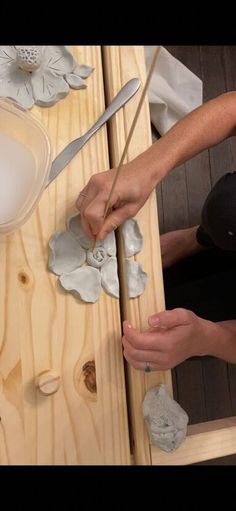 two people working on some art work with wood planks and paper machils in front of them