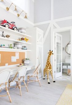 a giraffe standing in the middle of a living room next to a desk