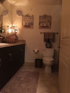 a bathroom with a toilet, sink, and mirror in it's center area