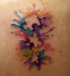 the back of a person's shoulder with colorful paint splattered on it