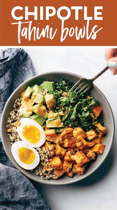 a bowl filled with rice, eggs and spinach on top of a white table