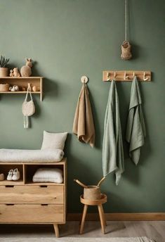 a room with green walls and wooden shelves filled with towels, shoes and other items