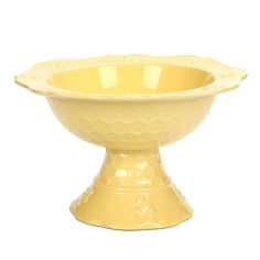 a yellow ceramic bowl sitting on top of a white table