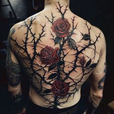 a man with tattoos on his back has roses and thorns growing out of it