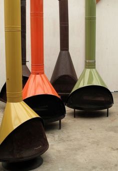 four different colored vases sitting next to each other on the floor in front of a white wall