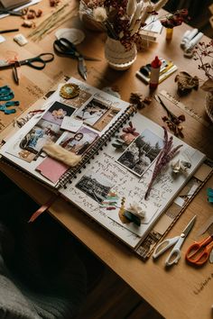 an open book sitting on top of a wooden table next to scissors and other crafting supplies