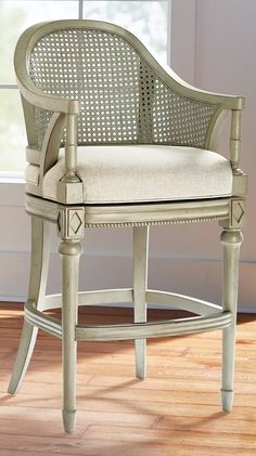 a white chair sitting in front of a window on top of a hard wood floor