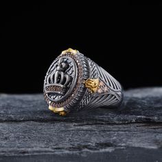 a silver and gold ring sitting on top of a wooden table