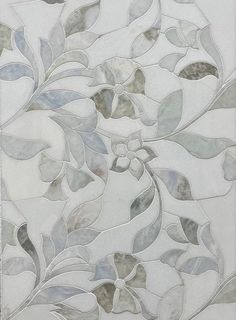 an artistic tile design with leaves and flowers on the side of a wall in grey tones