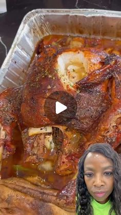 a woman standing in front of a roasting pan filled with meat