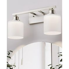 two light bathroom vanity fixture with white glass shades on the top and bottom lights above it