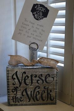 a sign that says verse of the week in front of a window with shutters